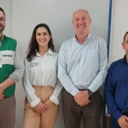 Na imagem quatro pessoas estão lado a lado. À esquerda, o diretor-executivo do Procon RS Rainer Grigolo, vestido com o colete do PROCON. Ao lado direito dele, está a servidora de Santa Rosa, Ângela de Paula, mulher branca, cabelos castanhos compridos e com uma camisa branca. Ao lado direito dela, está o vice-prefeito de Santa Rosa, Aldemir Ulrich Taquari, homem branco, calvo, de camisa azul clara. E à direita dele, está o procurador do Município, Flávio Fagundes, de camisa azul escura. 